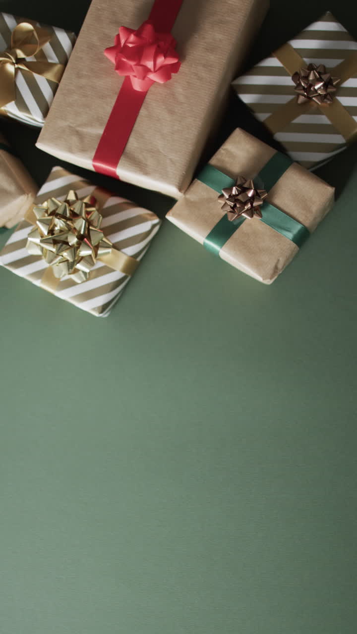 Vertical video of christmas presents and copy space on green background