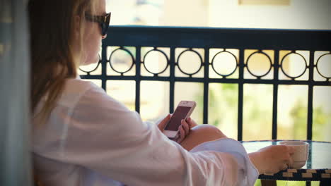 mujer escribiendo mensajes de texto y tomando té