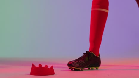 african american female rugby player with rugby ball over neon pink lighting