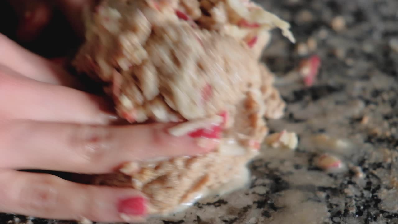 cerca de manos de mujer uniendo manzanas ralladas con masa de trigo integral