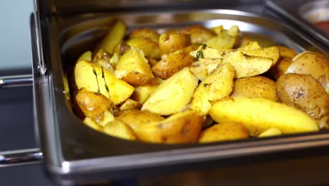 delicious baked potatoes in a buffet in a metal bowl at an event