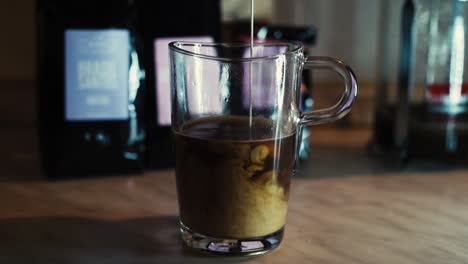 pouring white cream in a speciality dark coffee from africa