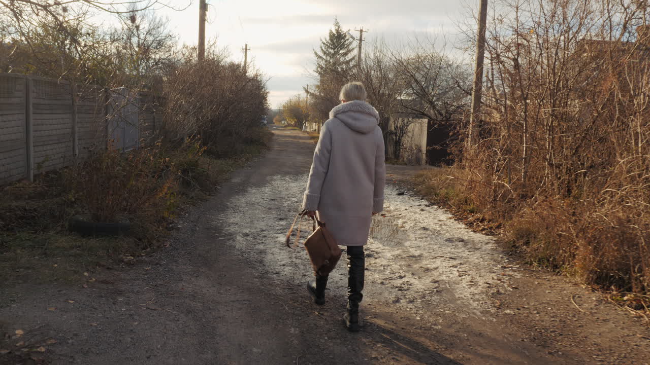 Donna che cammina su una strada rurale in autunno