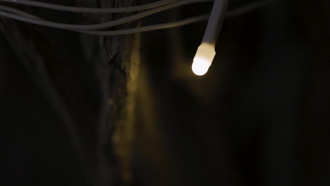 A single glowing light bulb in the dark