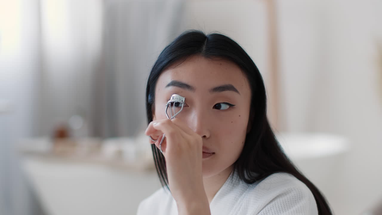 Woman Applying Eyelash Curler