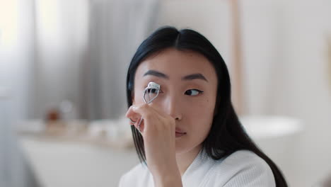 woman applying eyelash curler