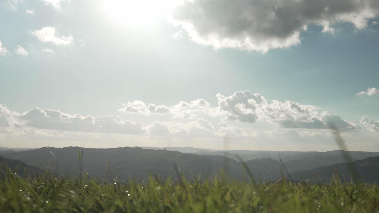 Landskabsudsigt over Sauerlands bakkede landskaber set fra Wildewiese-engen med dramatisk himmel og klart sollys.