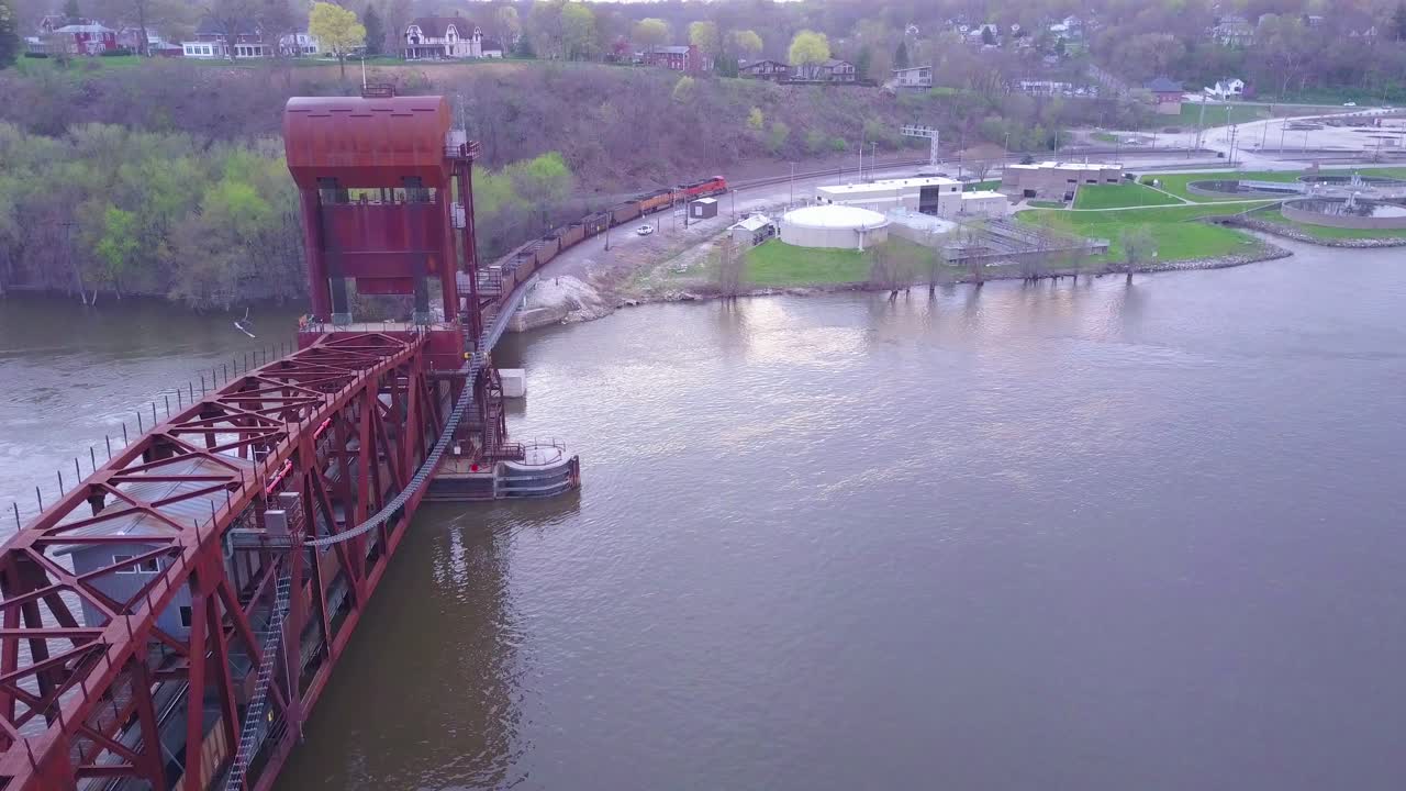 미시시피 강 위의 긴 현수교를 건너는 석탄 화물 열차의 항공 1