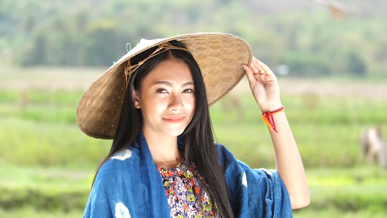Woman in traditional clothing, smiling in a rice paddy