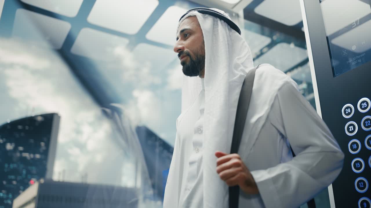 Successful Happy Muslim Businessman in Traditional White Kandura Riding Glass Elevator to Office in Modern Business Center. Saudi, Emirati, Arab Businessman Concept.