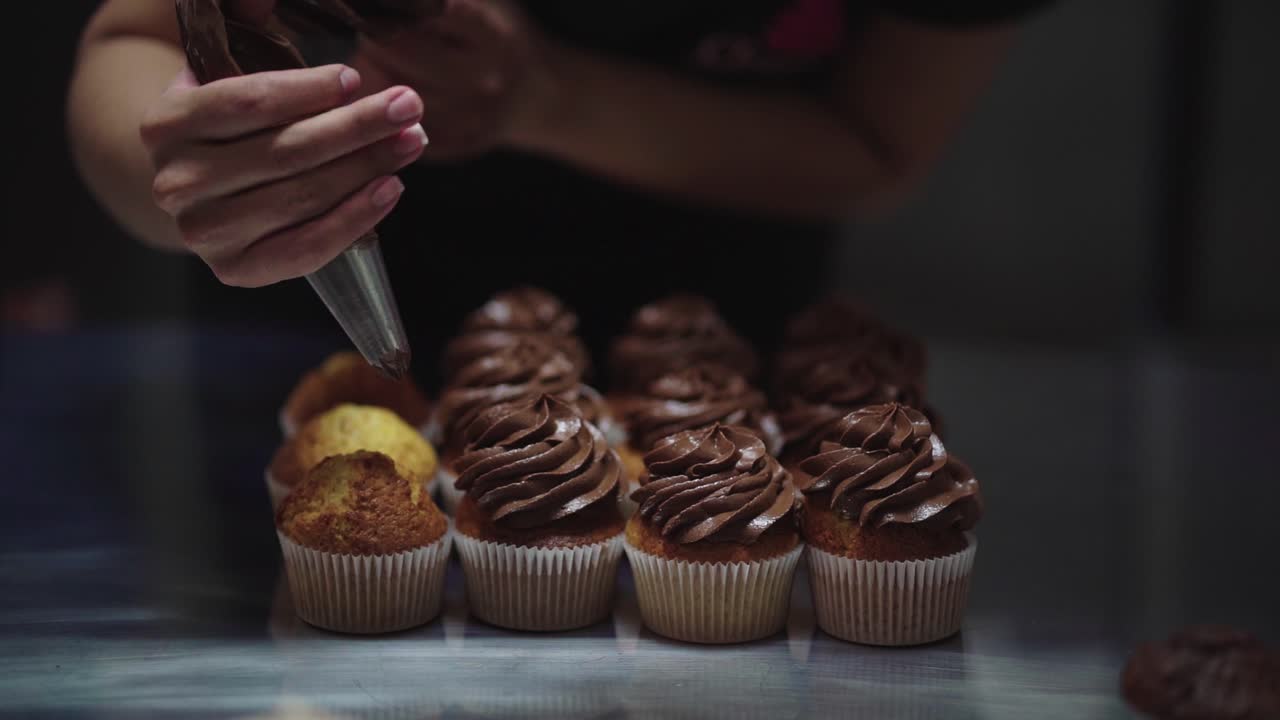 Mulher aplicando creme em muffins
