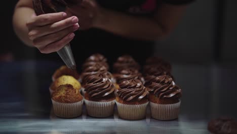 woman squeezing cream on muffins