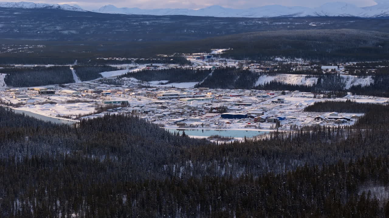 захватывающий поздний день воздушный вид на уайтхорс, юкон. снежные пейзажи и замерзшая река юкон мерцают под закатным светом.