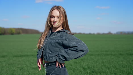 sexy girl posing outdoors. beautiful young woman with long hair walking on a green meadow and looking on camera.
