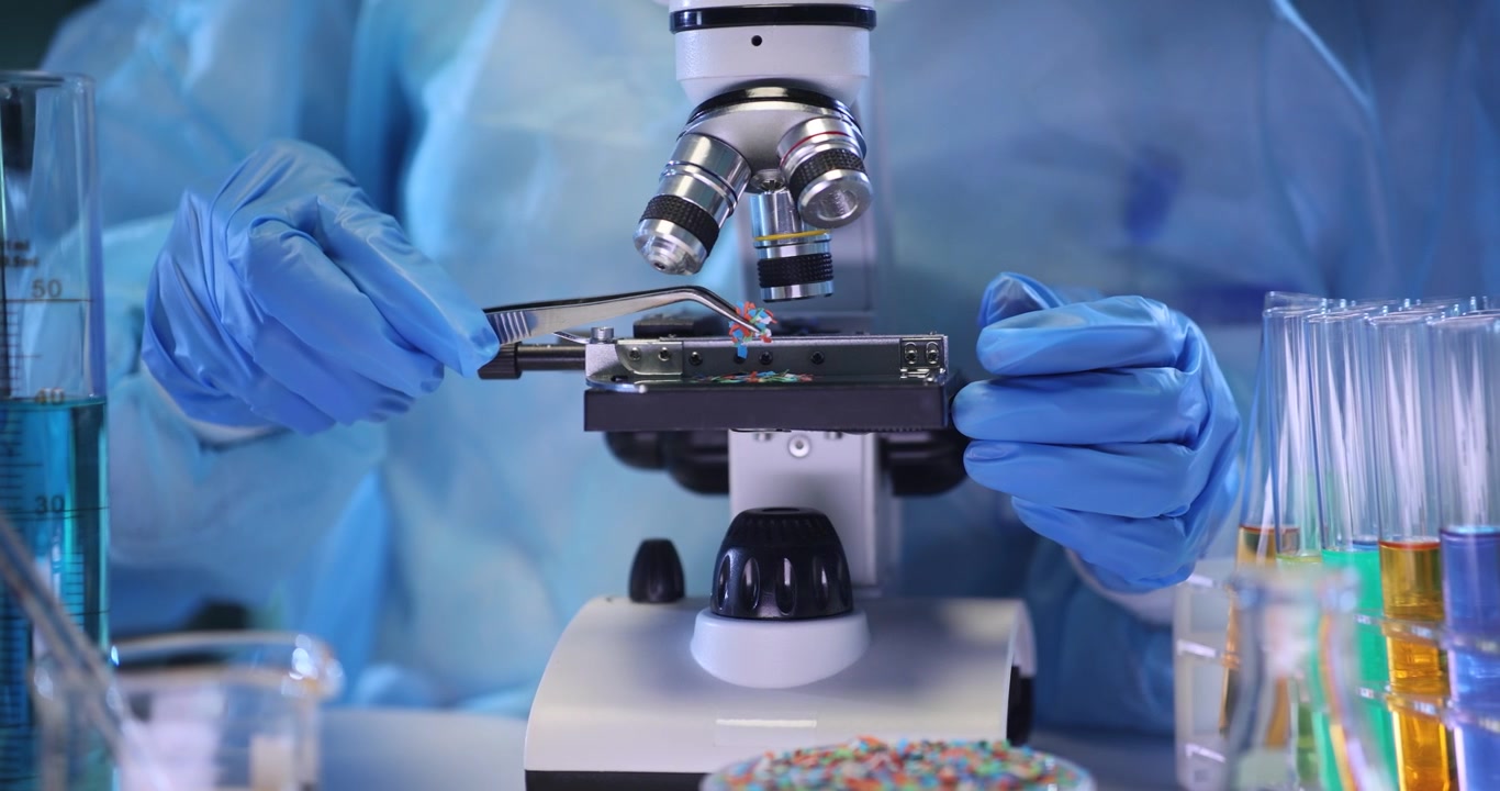 Technician places microplastic particles onto microscope slide