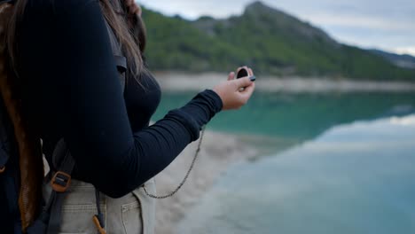 person with pocket watch by the lake