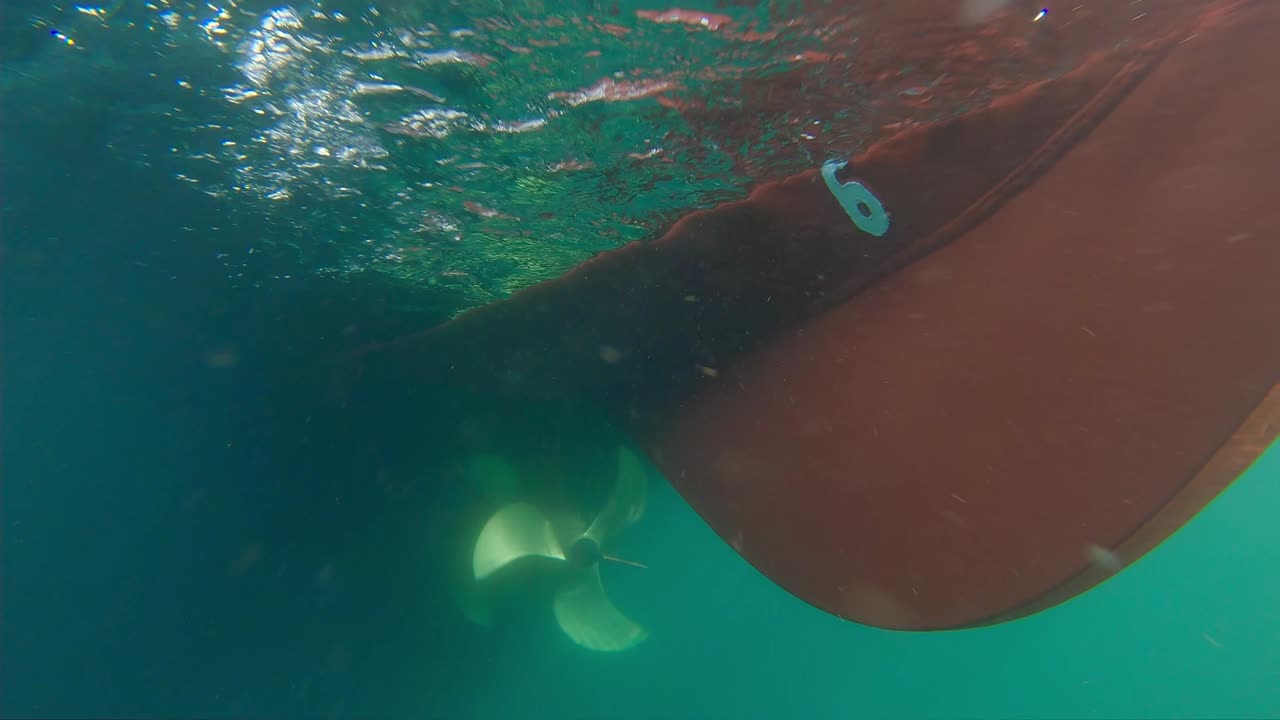 clip de acción de barcos giratorios propulsados por baterías hélice empujando agua y partículas contra la cámara - clip submarino en cámara lenta