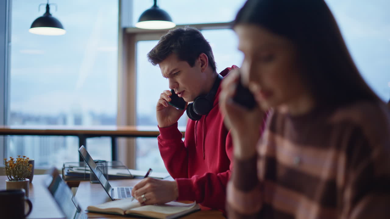 People working in an office using laptops and phones