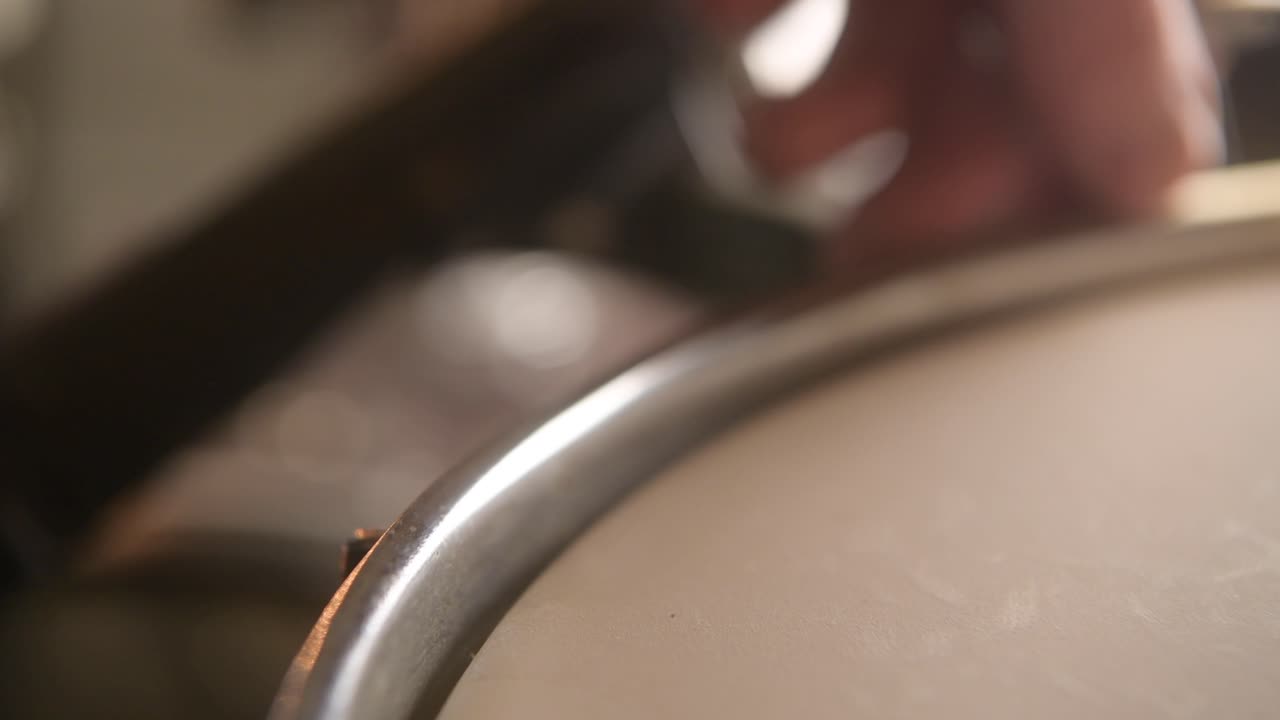 el baterista afinando los tom toms para preparar el kit de batería para la grabación