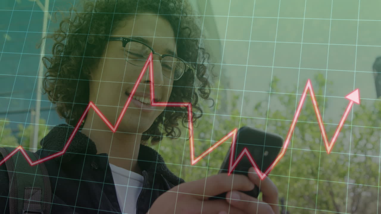 Animation of graphs and grid pattern over low angle view of smiling biracial man using cellphone