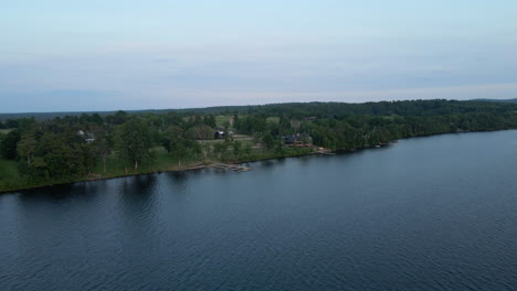 flying over lake and green tree covered coastline with cottages and docks throughout. calabogie ontario