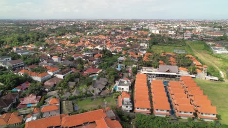 Berawa-Residential-Buildings-and-Rental-Villa-Resorts-Houses-With-Orange-Roofs-in-Bali,-Indonesia---Aerial-Flyover