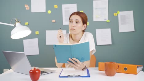 woman with notebook thinks and takes notes.