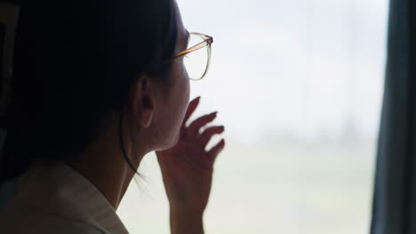 pensive woman looks out the window for inspiration