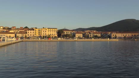 sunset light hitting the concrete pier and buildings along the shore of vela luka in croatia