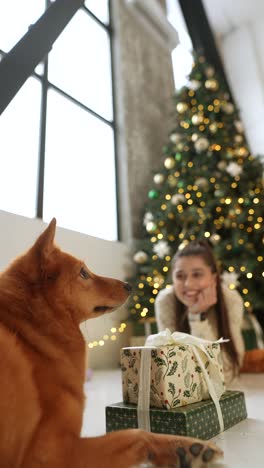 perro y niña cerca del árbol de navidad con regalos