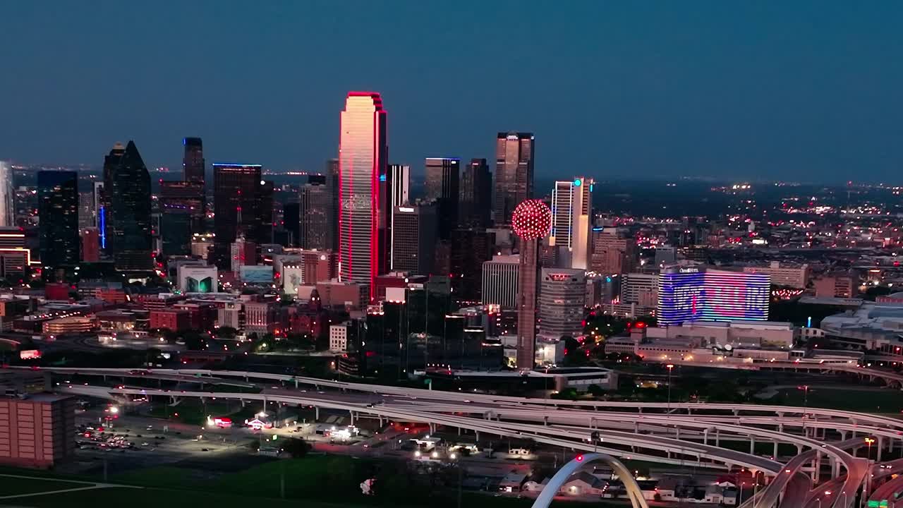 Şehir ışıkları ve parıldayan binalarla birlikte Dallas şehir merkezinin gece havadan görünümü