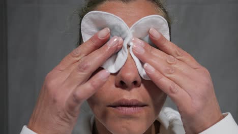 close-up of a woman's face as she wipes away her make-up and cleans her face