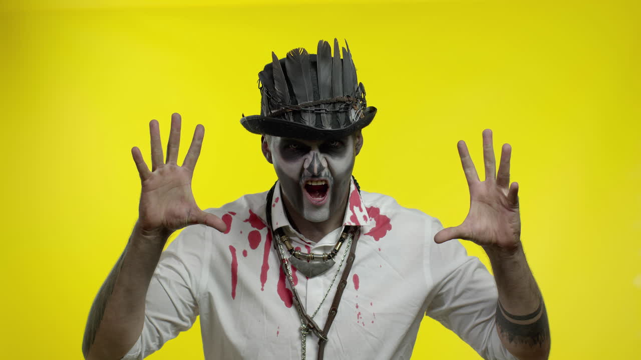 hombre siniestro con horrible maquillaje de esqueleto de halloween haciendo caras, mirando a la cámara tratando de asustar