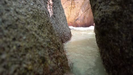 a corridor of stones on the beach. water flows.