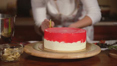 woman decorating a beautiful red and white layer cake