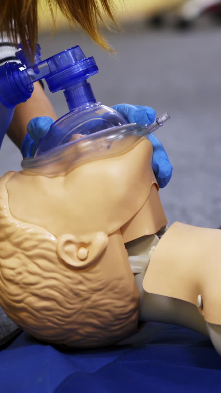 Training course on a manikin. Practitioners giving breath exercises on a dummy at resuscitation. Compression during heart attack on a mannequin. Vertical video
