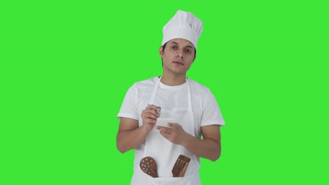 chef profesional indio anotando la receta pantalla verde