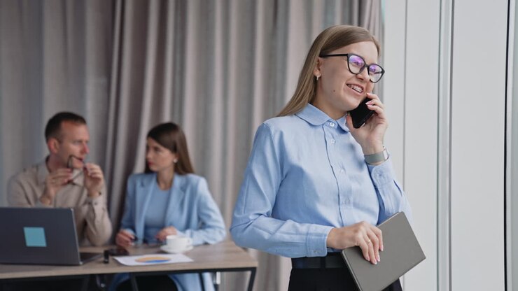 Forretningskvinne i telefonsamtale på moderne kontor