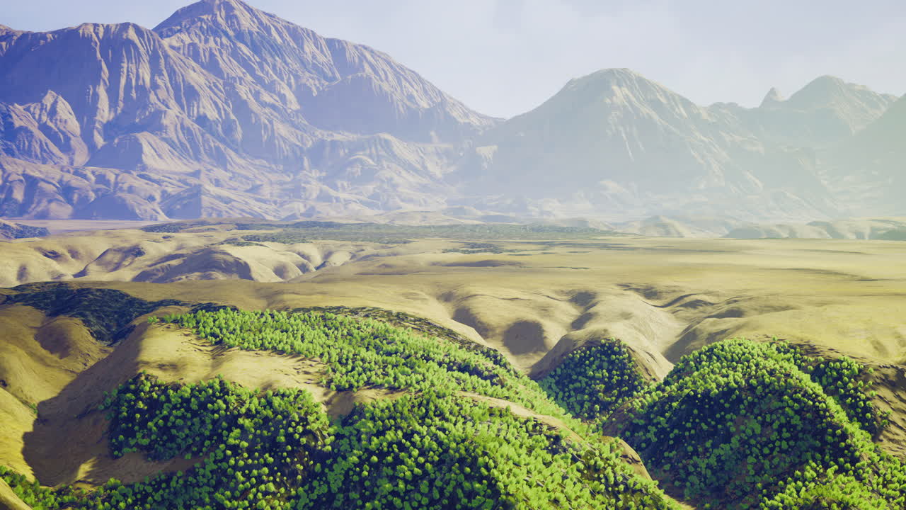 Lush green hills meet majestic mountain peaks under a clear sky