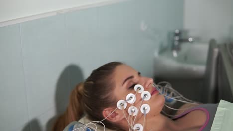 woman undergoing facial treatment with electrodes