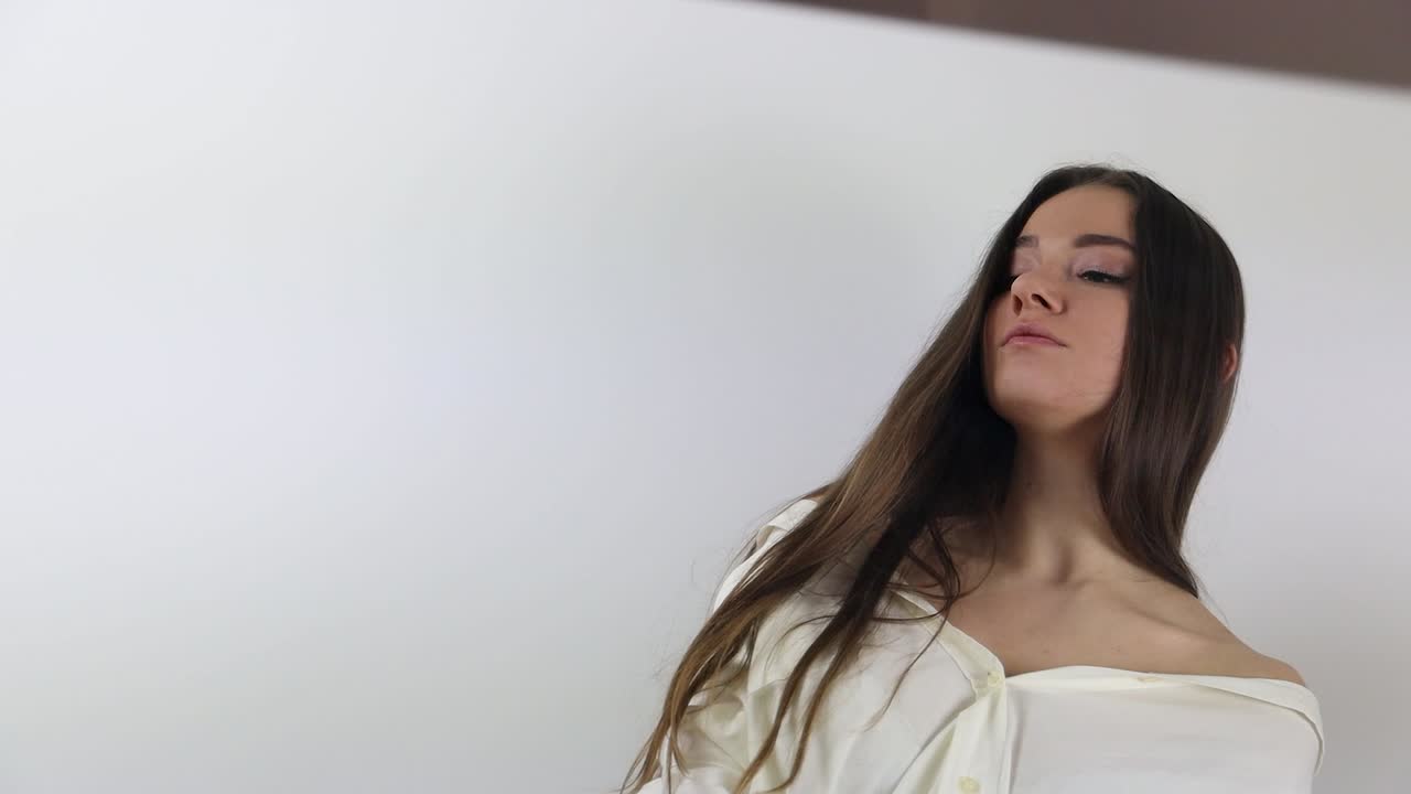 미러 앞 에서 포즈 를 취하고 있는 사려 깊고 순종적 인 여성 모델