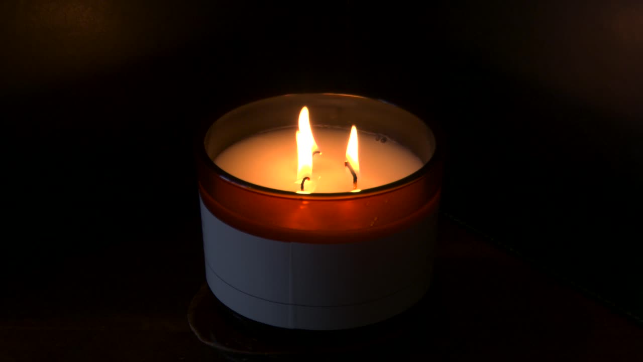 4k, rallentatore, tre candele accese con sfondo scuro