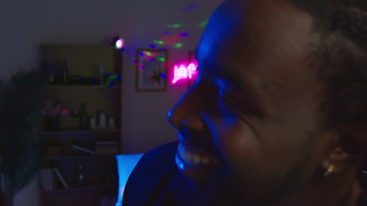 Young Couple Having Fun Dancing And Drinking Alcohol At House Party Together