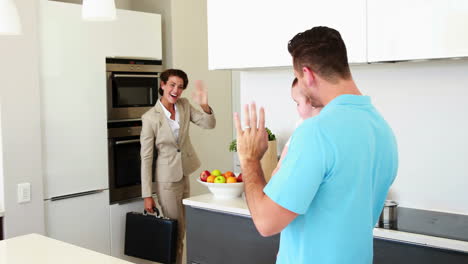 madre que trabaja saludando a casa marido y bebé
