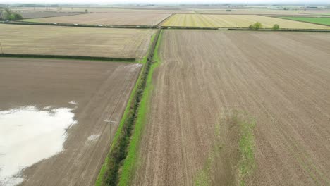 Imágenes-De-Drones-Volando-Sobre-Campos-Arados,-A-Lo-Largo-De-Setos-Y-Sobre-Una-Carretera-Secundaria