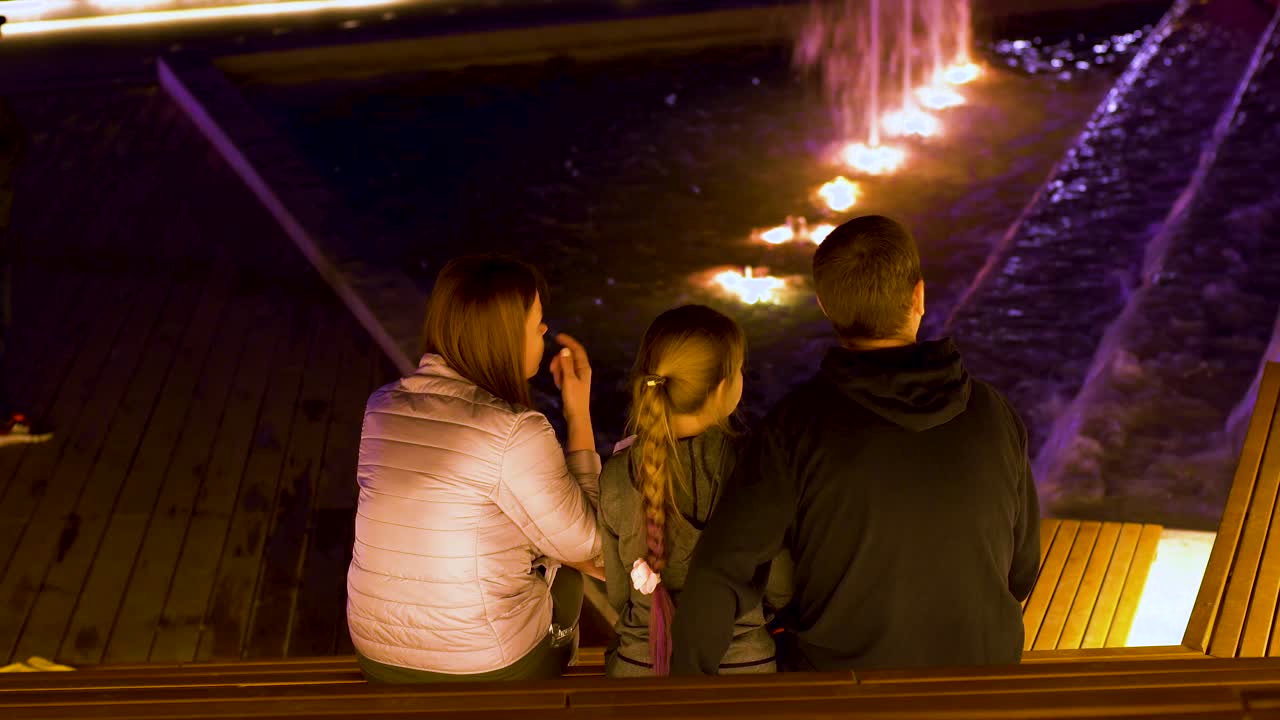 밤 에 분수 쇼 를 즐기는 가족