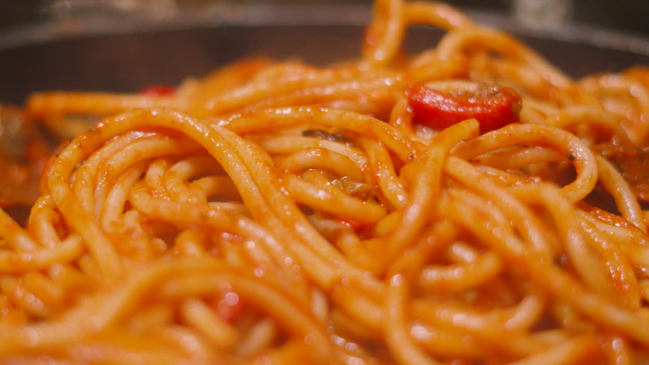 Italian Tomato Based Pasta Bucatini Spaghetti with Aubergine Egg Plant and Peppers in Pan. Delcious Cooking Close Up Food Clip