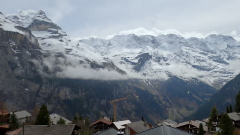 a very wide shot of a pair of paragliders in the swiss alps, switzerland