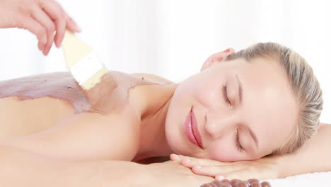 mujer recibiendo un tratamiento de belleza en la espalda
