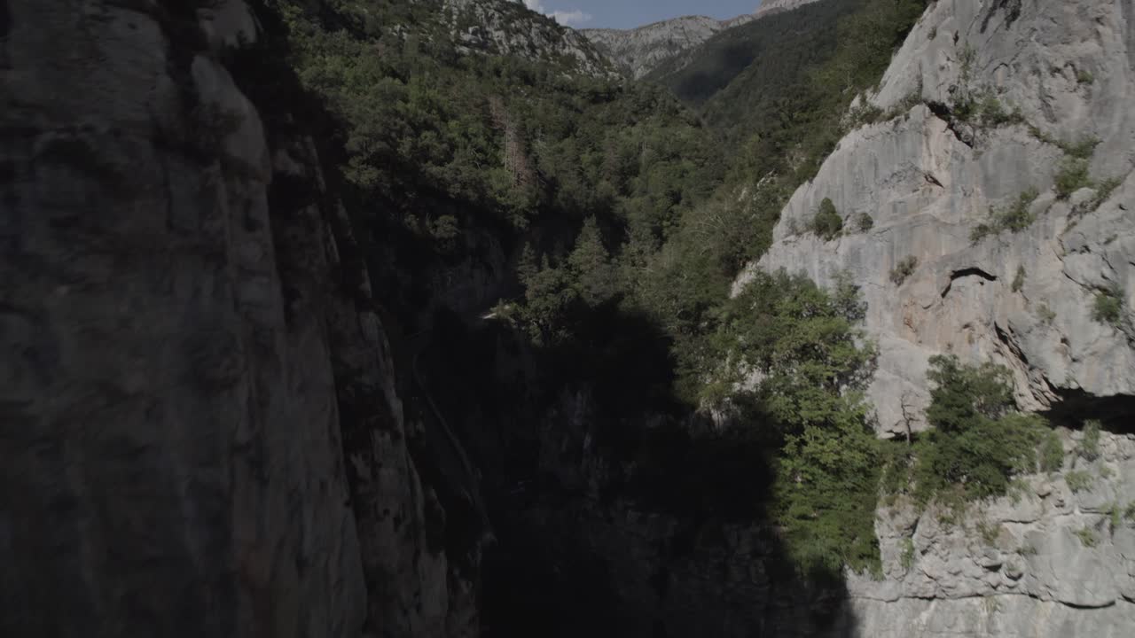 This drone video captures a breathtaking frontal shot along the Boca del Infierno Gorge road in the mountains of the Western Valleys Natural Park, Huesca, Spain. Stunning natural landscapes.